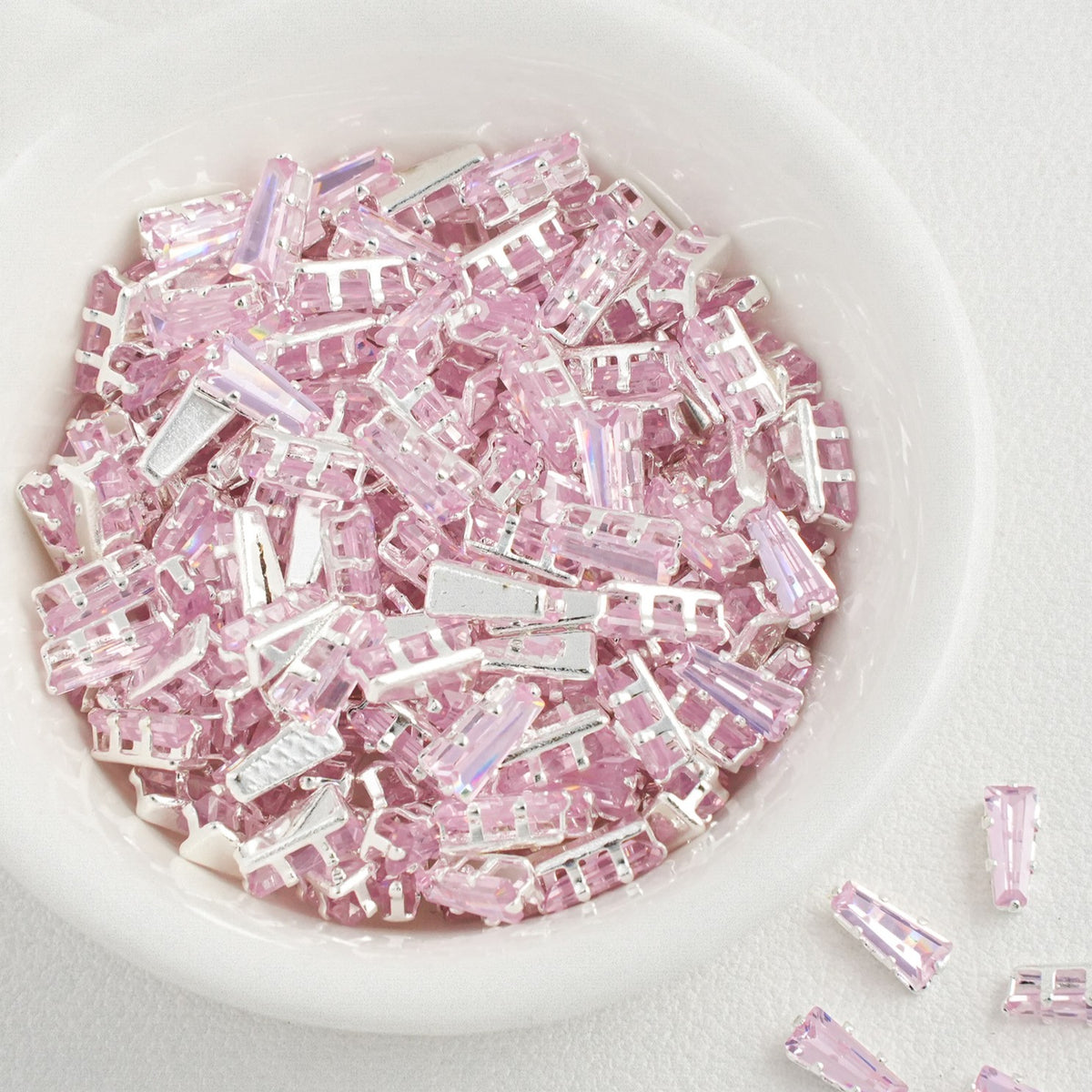 pink prong sew-on setting close-up, 2x3x6mm trapezoid CZ stone held by metal claws